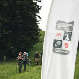 Wanderer hinter der Flagge des Fjällräven Classic Germany in Immenstadt im Allgäu.